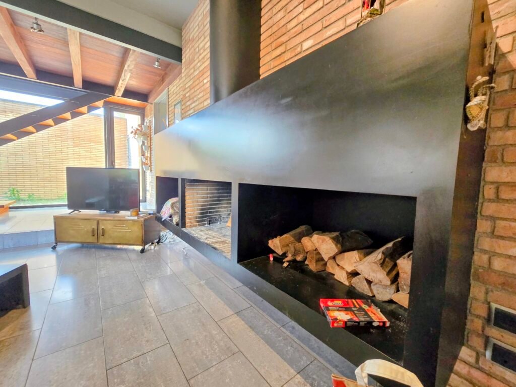 VCI029, Seva — salón con chimenea y ventanales hacia el jardín
